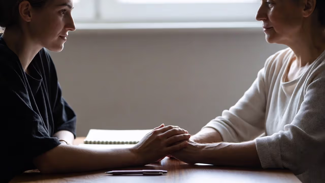 Couple holding hands at a table while resolving a conflict calmly