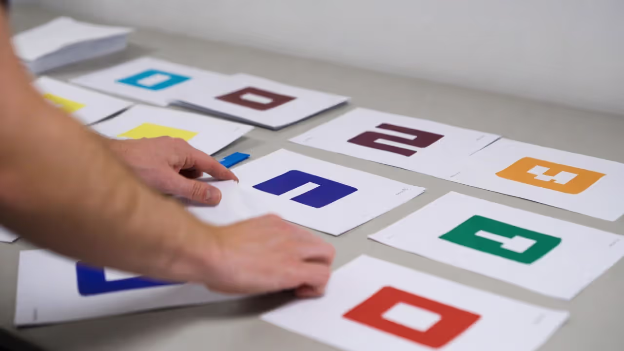Hand arranging several blank cards on a table, representing different parts of identity.